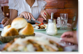 table spread with woman cutting into plate of turkey